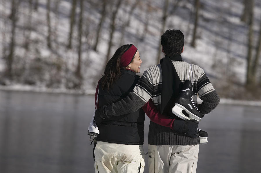 Couple with ice skates #1 Photograph by Comstock Images