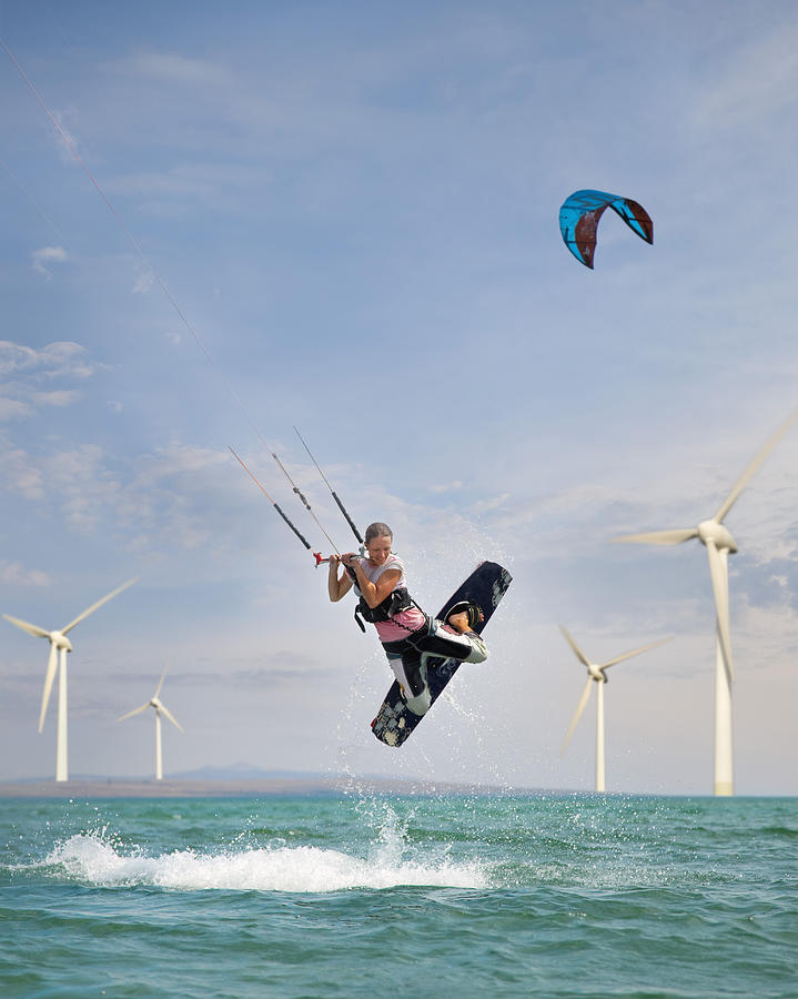 Croatia, Zadar, Kitesurfer jumping in front of wind turbine #1 Photograph by Westend61