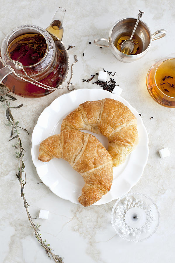 Croissants, honey and tea on table #1 Photograph by Magdalena Niemczyk - ElanArt