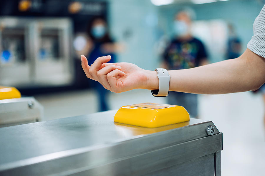 Cropped shot of young Asian woman checking in at subway station using contactless payment for subway ticket via smartwatch #1 Photograph by D3sign
