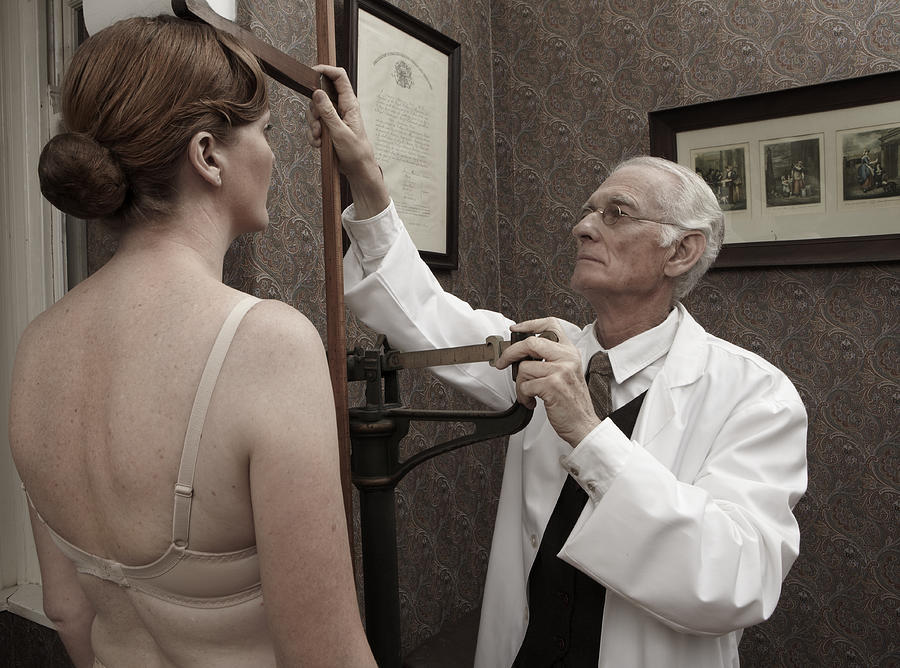 Doctor measuring female patients height #1 Photograph by Smile