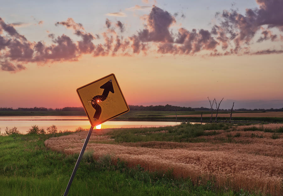 Dodged a Bullet - curve in road sign with sunlight through bullet hole Photograph by Peter Herman