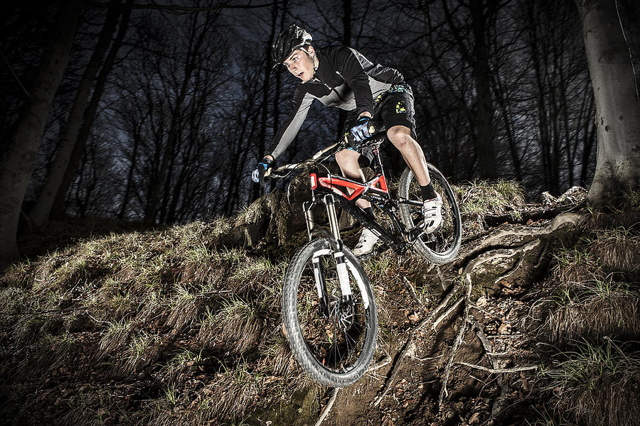 Downhill enduro mountain bike jump in the woods. #1 Photograph by Ilbusca