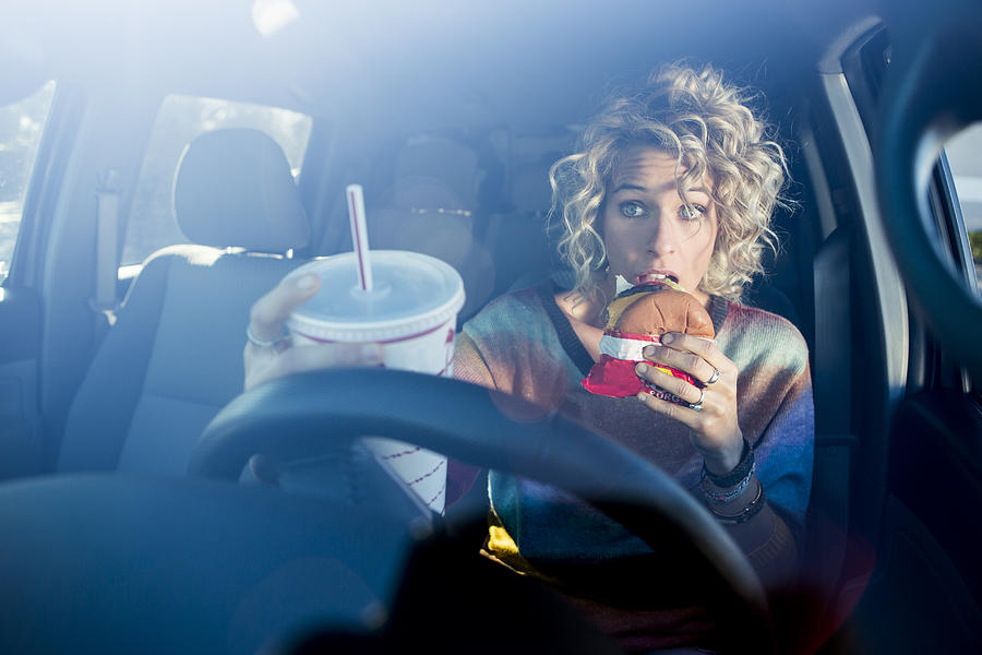 Eating fast food hamburgers and driving. #1 Photograph by Jordan Siemens