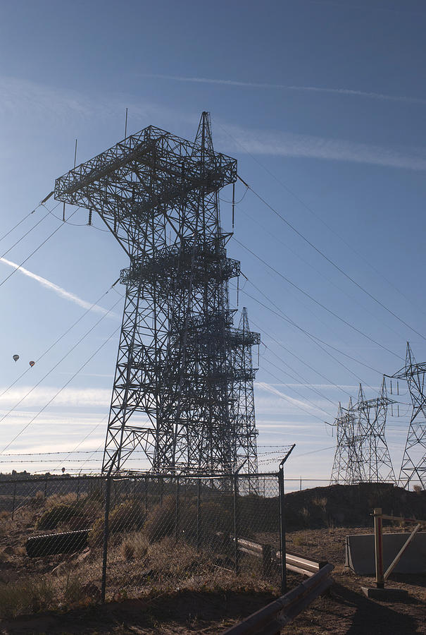 Electricity pylons over a dam #1 Photograph by Fotosearch