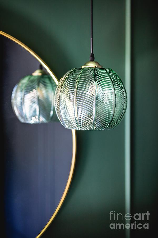 Elegant retro lamp hanging next to a mirror on dark green wall