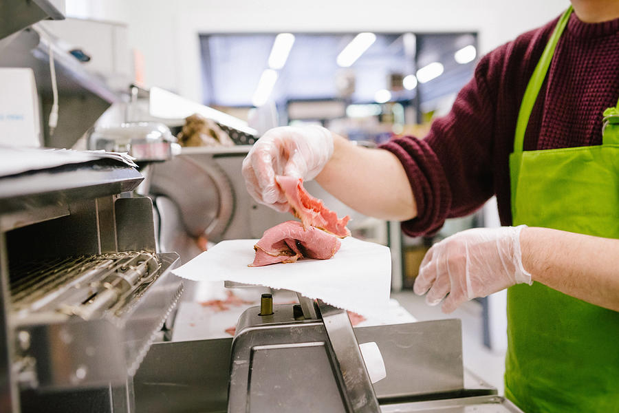 Employee in general store weighing sliced meat in kitchen #1 Photograph by Heshphoto