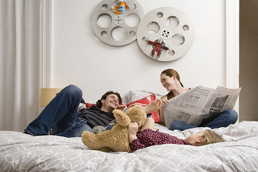Family relaxing on bed #1 Photograph by Image Source