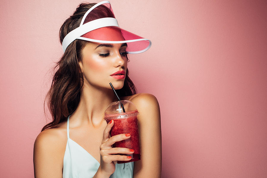 Fashion pretty cool girl drinks from cup over pink background #1 Photograph by CoffeeAndMilk