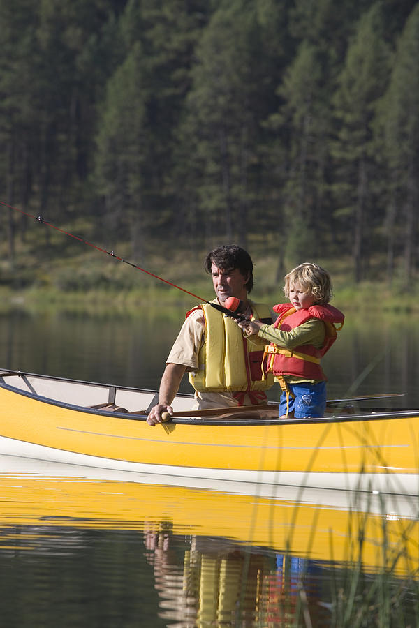 Father and child fishing in a canoe #1 Photograph by Comstock Images