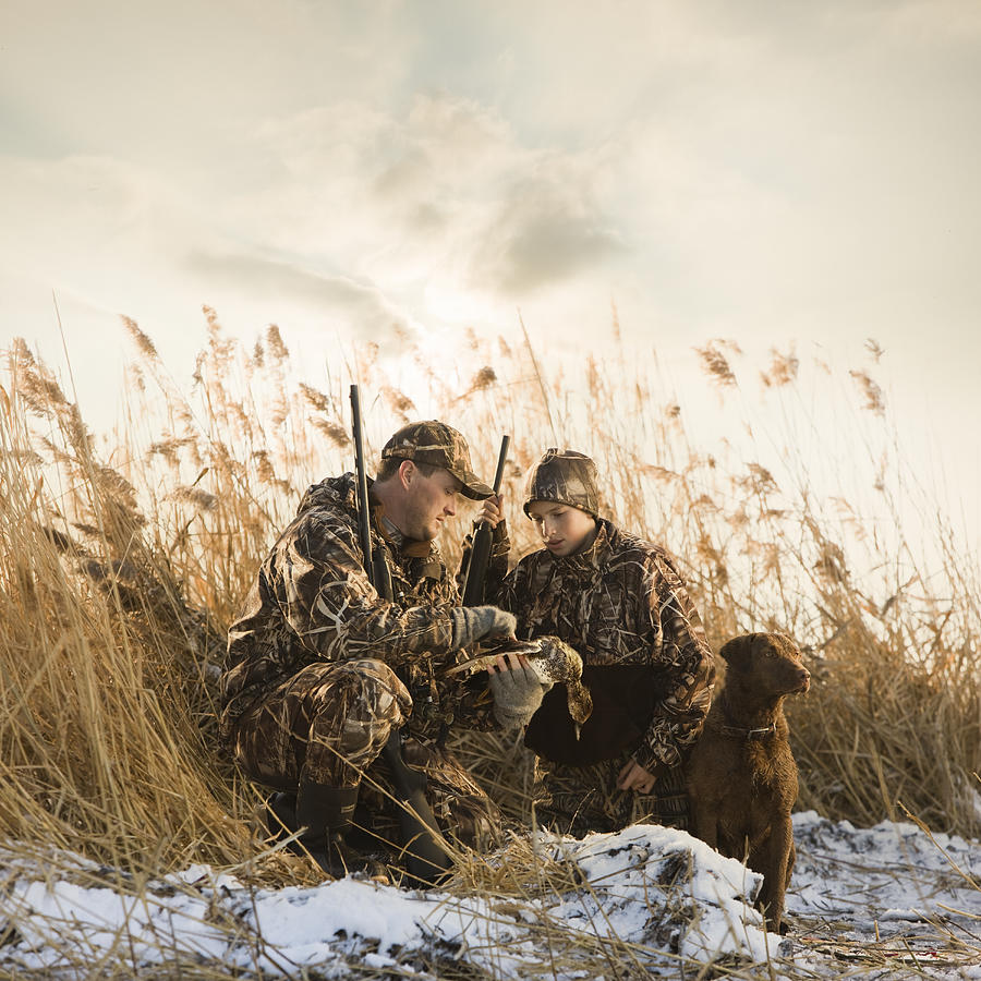 Father And Son Duck Hunting With Their Dog #1 Photograph by RubberBall Productions