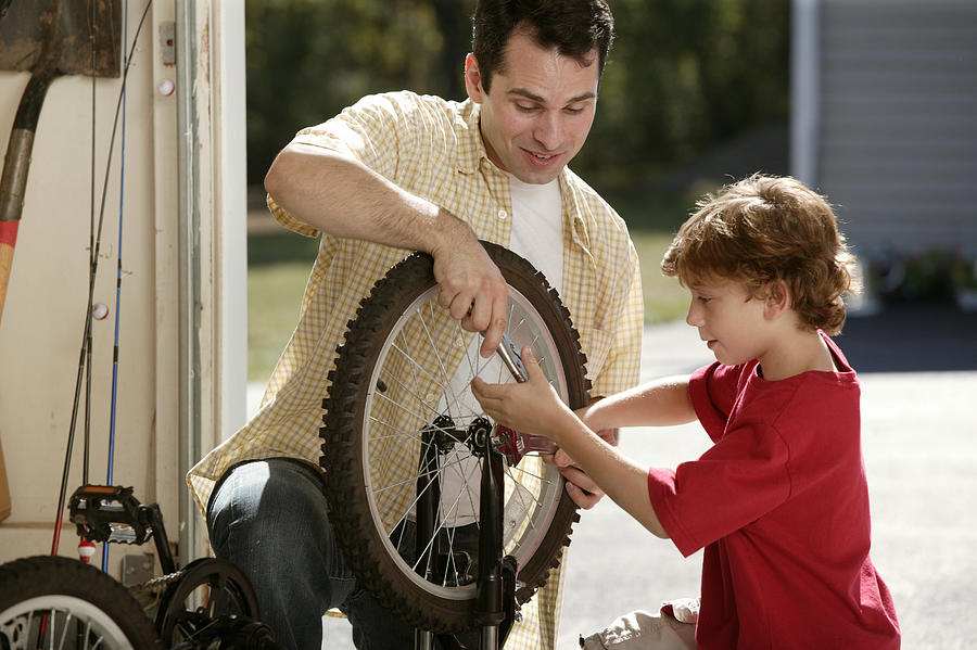 Father and son fixing bicycle #1 Photograph by Comstock Images