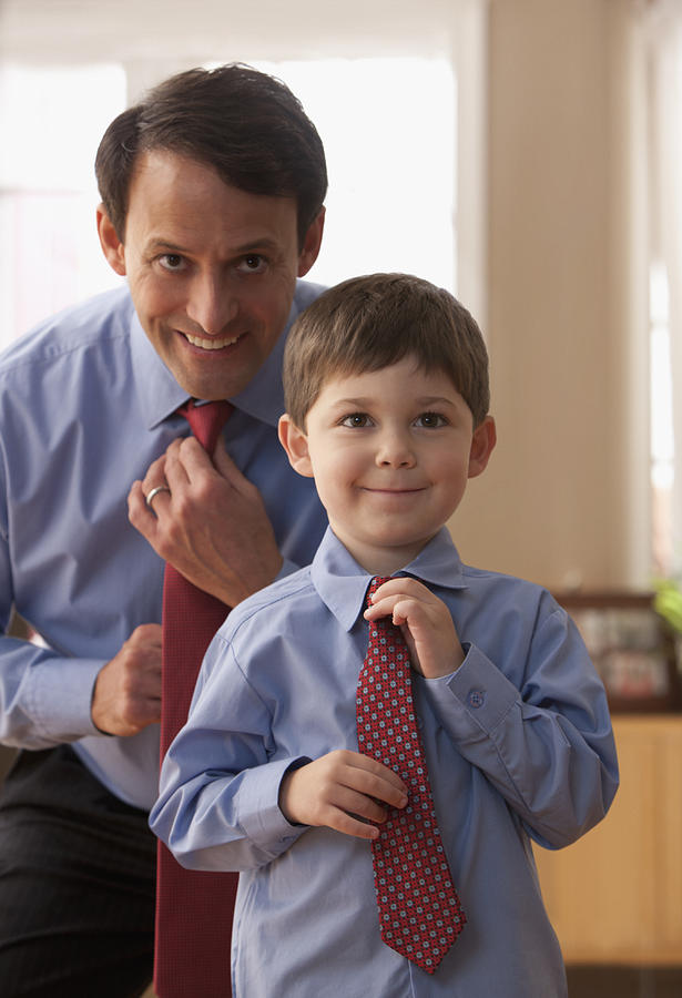 Father and son fixing ties together #1 Photograph by SelectStock