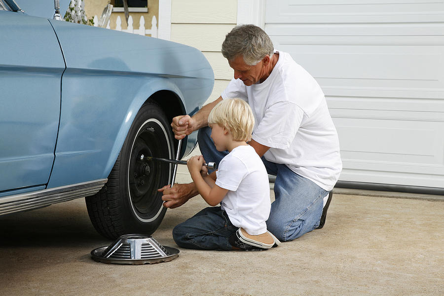 Father And Son Working On The Car #1 Photograph by Skodonnell