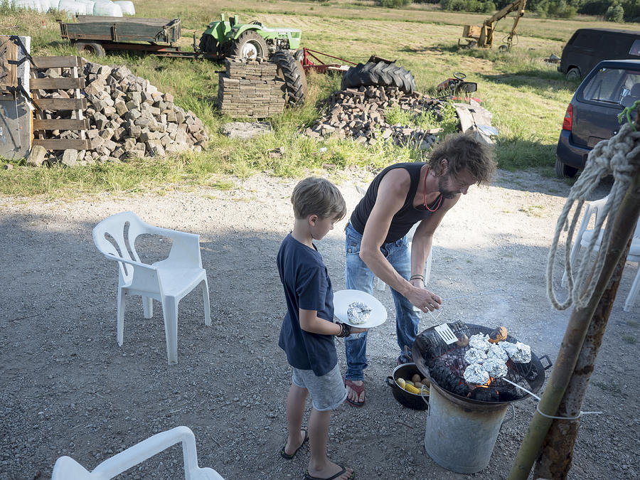 Father preparing food with his son #1 Photograph by Lucy Lambriex