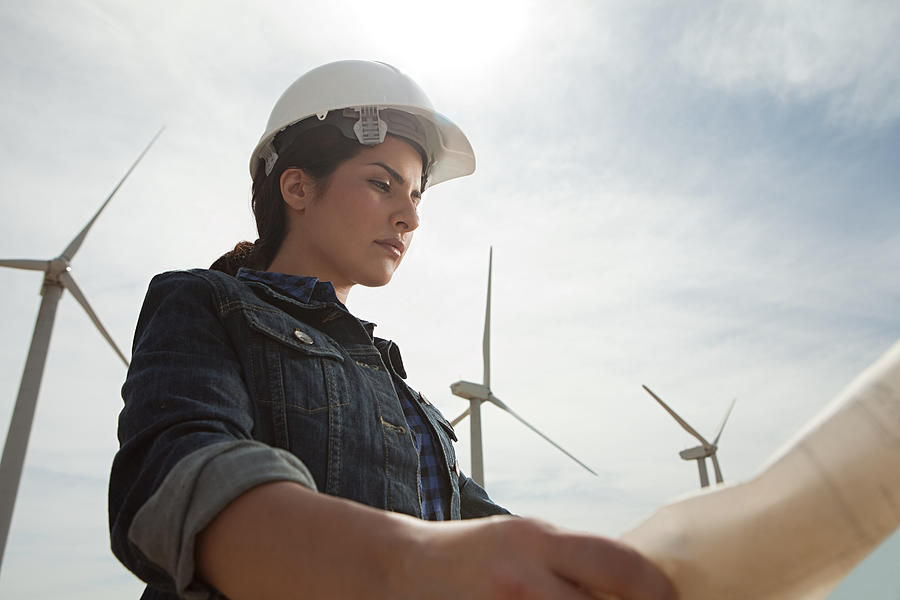 Female engineer at wind farm with plans #1 Photograph by Image Source