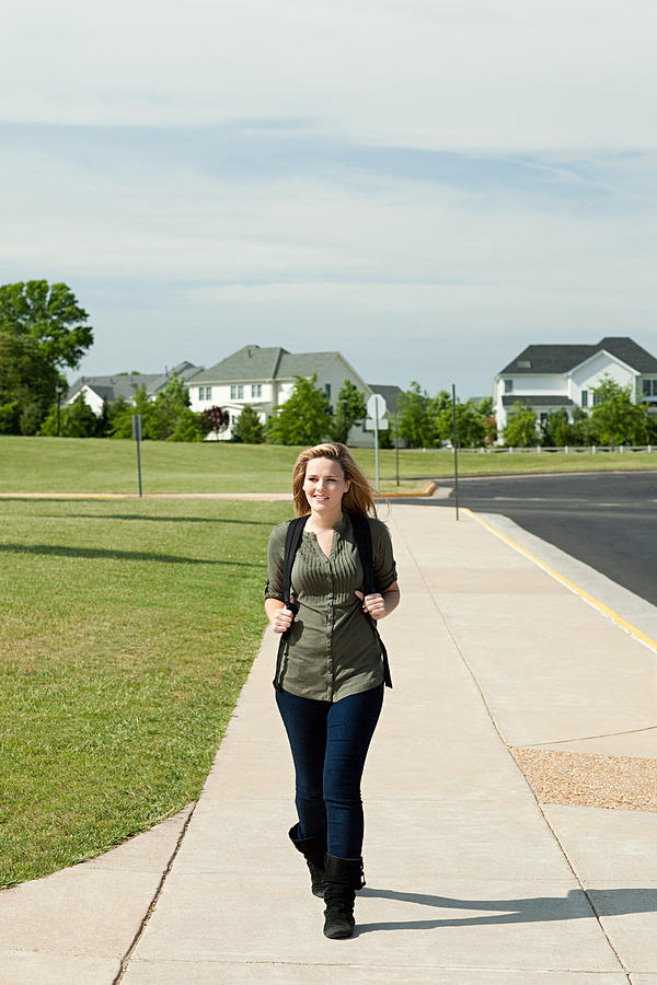 Female high school student walking along pavement #1 Photograph by Image Source