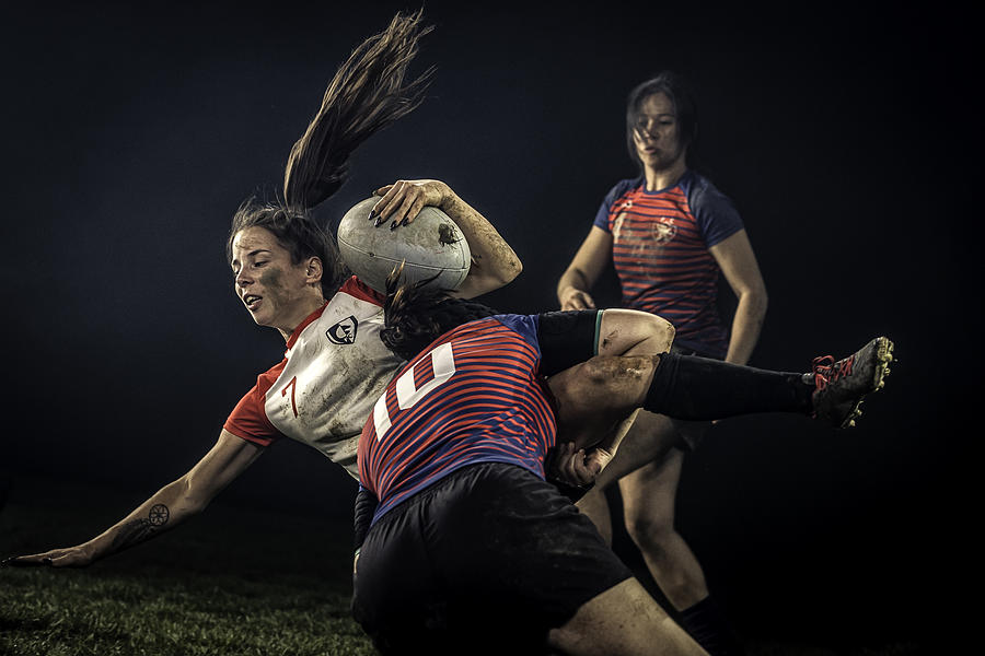 Female rugby player getting tackled #1 Photograph by Vm