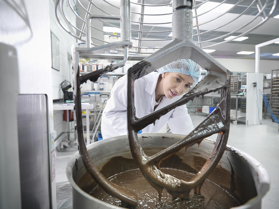 Female worker mixes chocolate in cake factory #1 Photograph by Monty Rakusen