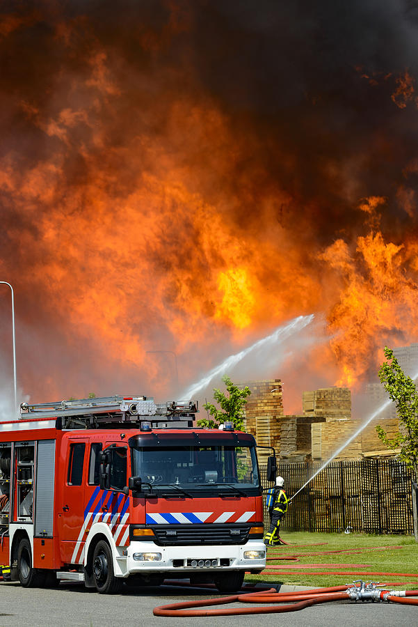 Fire truck in front of a large fire in a factory in an industrial area #1 Photograph by Sjo