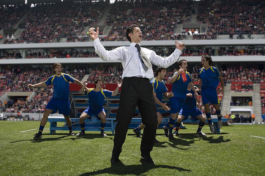 Football manager and footballers celebrating #1 Photograph by Image Source