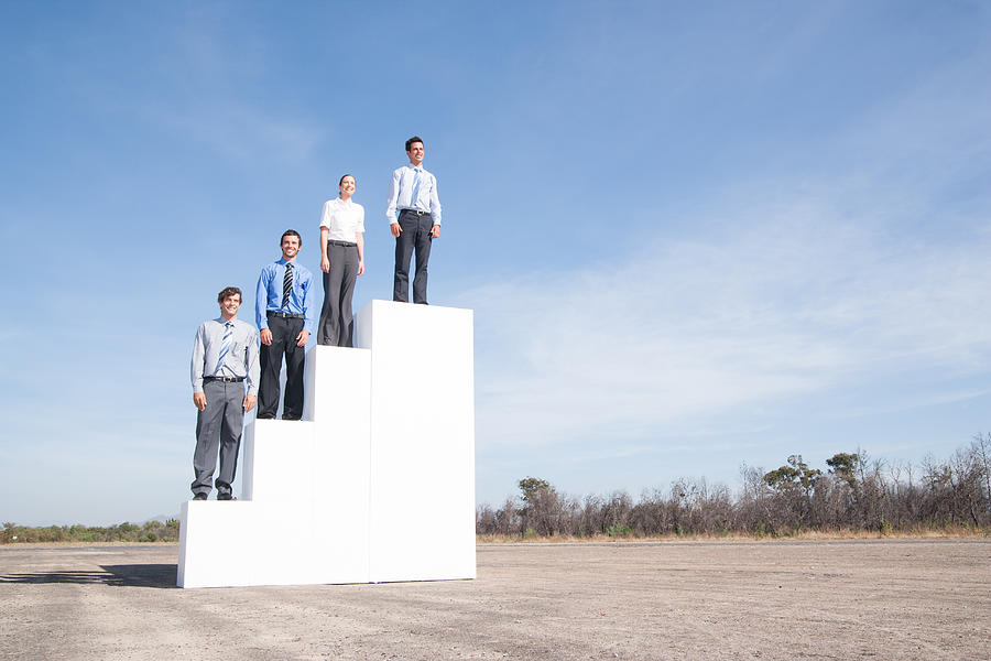 Four businesspeople standing on steps outdoors #1 Photograph by Martin Barraud