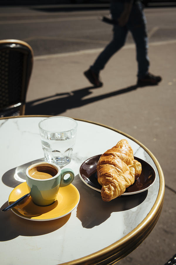 France, Paris, Croissant, coffee and glass of water on sidewalk cafe table #1 Photograph by Ben Pipe Photography