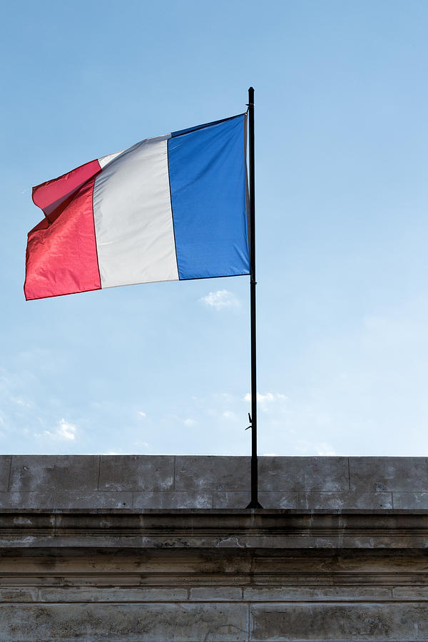 French tricolor flag floating in a blue sky #1 Photograph by Jean-Marc PAYET