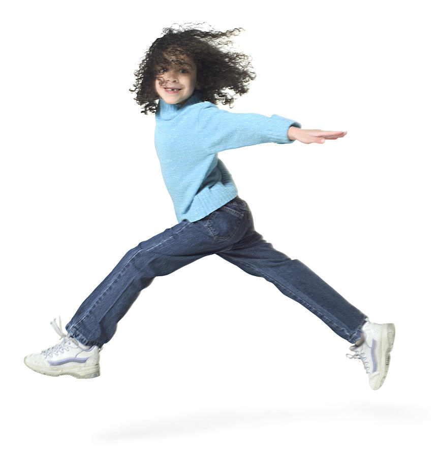 Full Body Shot Of A Female Child As She Runs And Jumps Playfully Through The Air #1 Photograph by Photodisc
