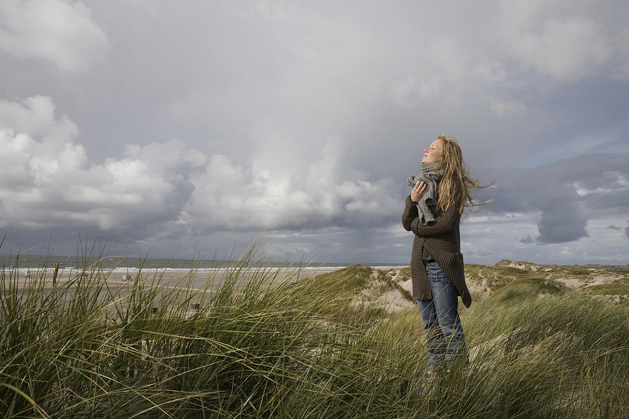 Germany, Schleswig Holstein, Amrum, Young woman on grassy sand dune #1 Photograph by Westend61