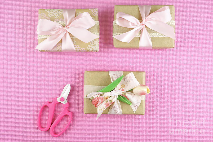 Gifts wrapped in kraft paper and pink ribbons overhead flatlay. #1 Photograph by Milleflore Images