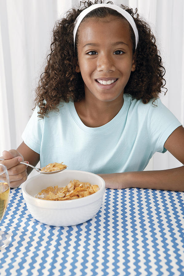 Girl eating breakfast at home #1 Photograph by Comstock Images