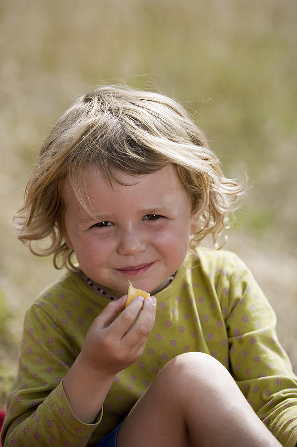 Girl eating fruit #1 Photograph by Comstock Images
