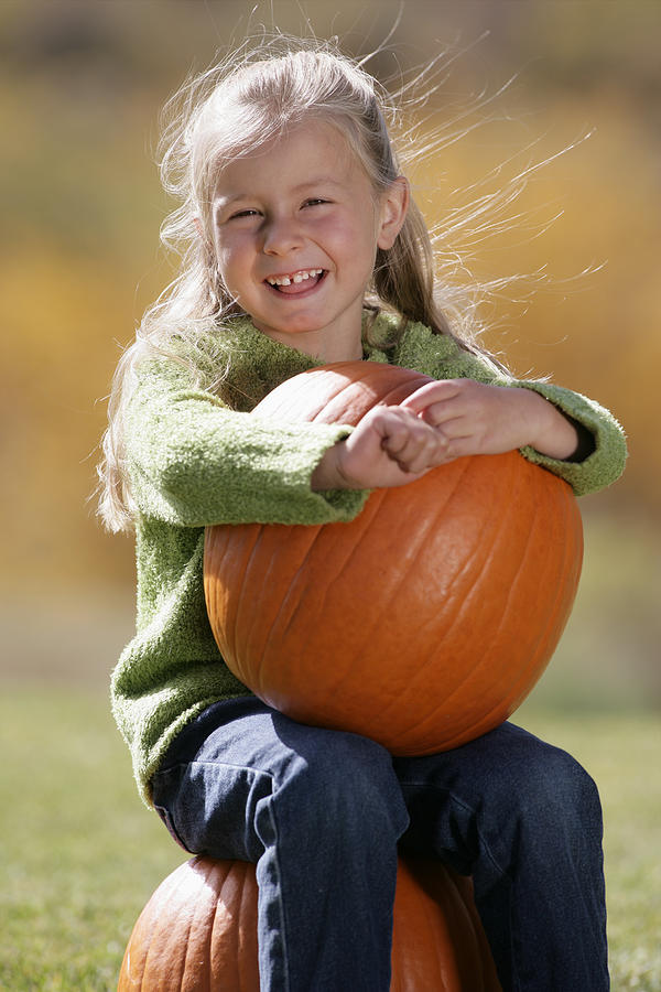 Girl holding a pumpkin #1 Photograph by Comstock Images