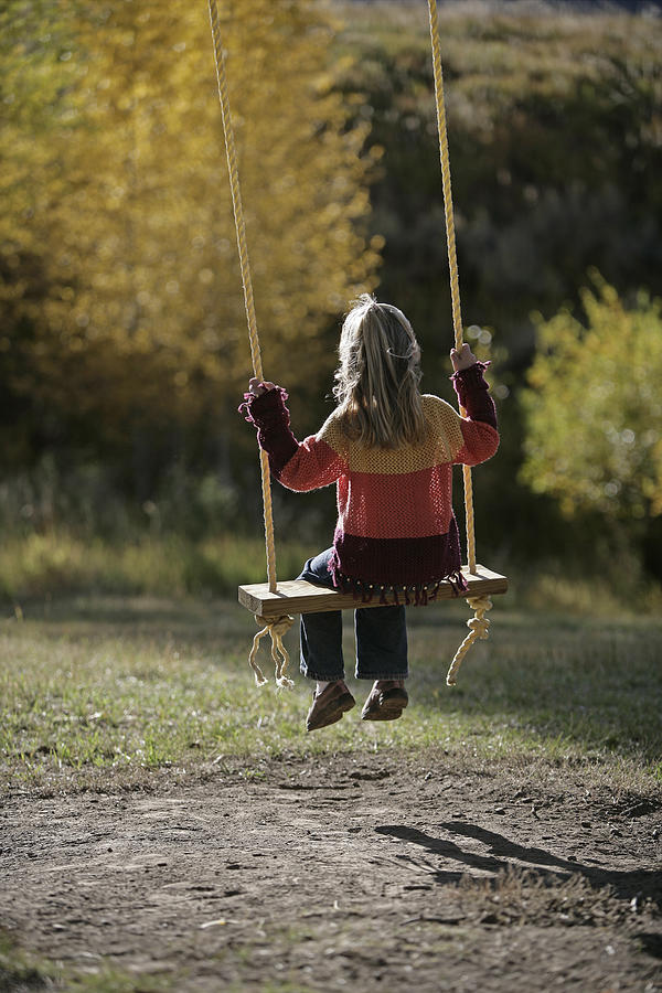 Girl sitting on a swing #1 Photograph by Comstock Images