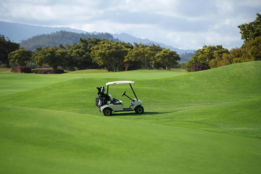 Golf cart in a golf course #1 Photograph by Glowimages
