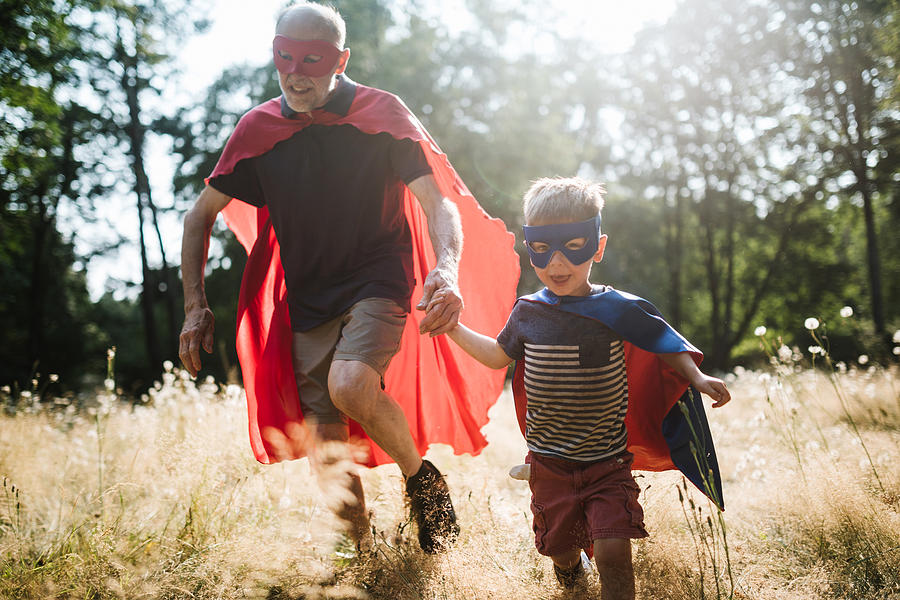 Grandfather Dressed As Superhero Plays Outside With Grandson #1 Photograph by RyanJLane