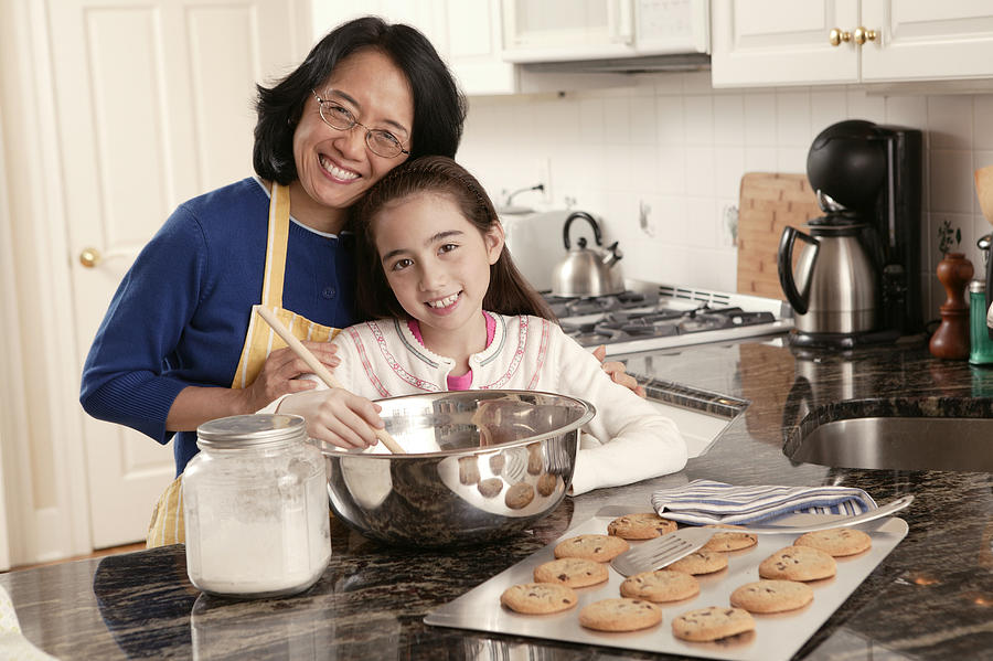 Grandmother and granddaughter baking cookies #1 Photograph by Comstock Images
