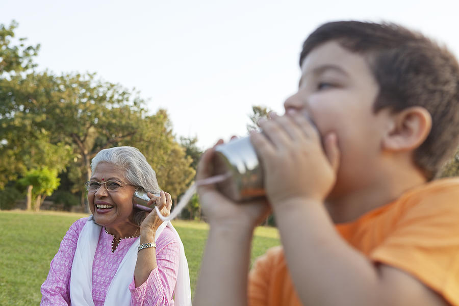 Grandmother and grandson talking through tin cans #1 Photograph by Ravi Ranjan