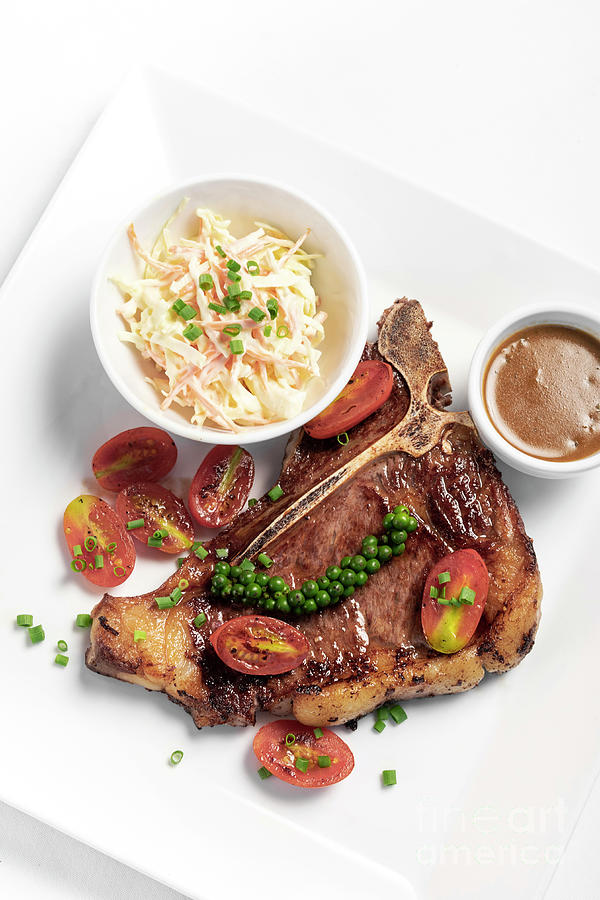 grilled T-Bone steak with coleslaw and gravy on white background Photograph