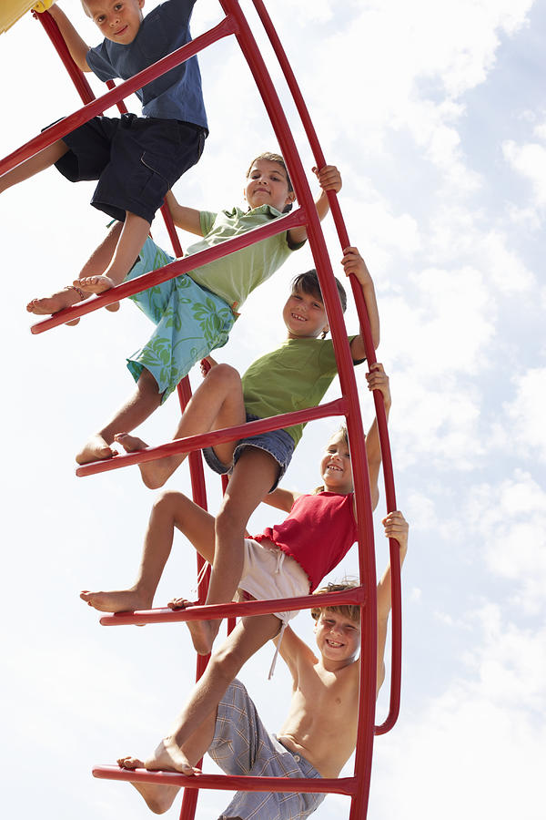 Group of children (6-9) on climbing frame, portrait, low angle view #1 Photograph by Christopher Robbins