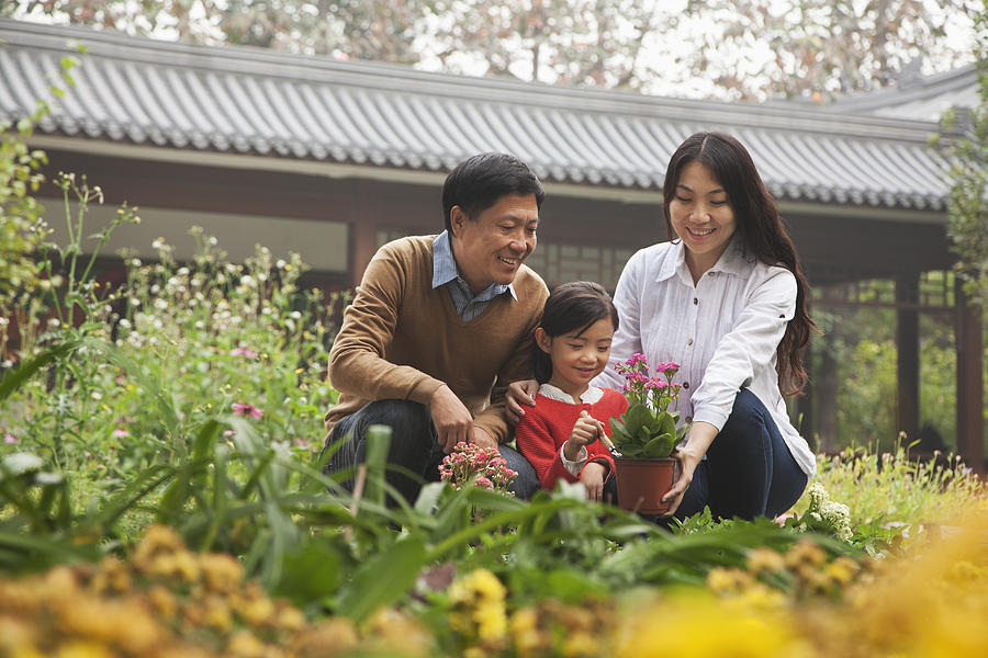 Happy family in garden Photograph by XiXinXing