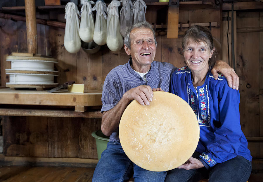 Happy Senior Swiss Couple Holding A Loaf Of Selfmade Cheese #1 Photograph by Elkor