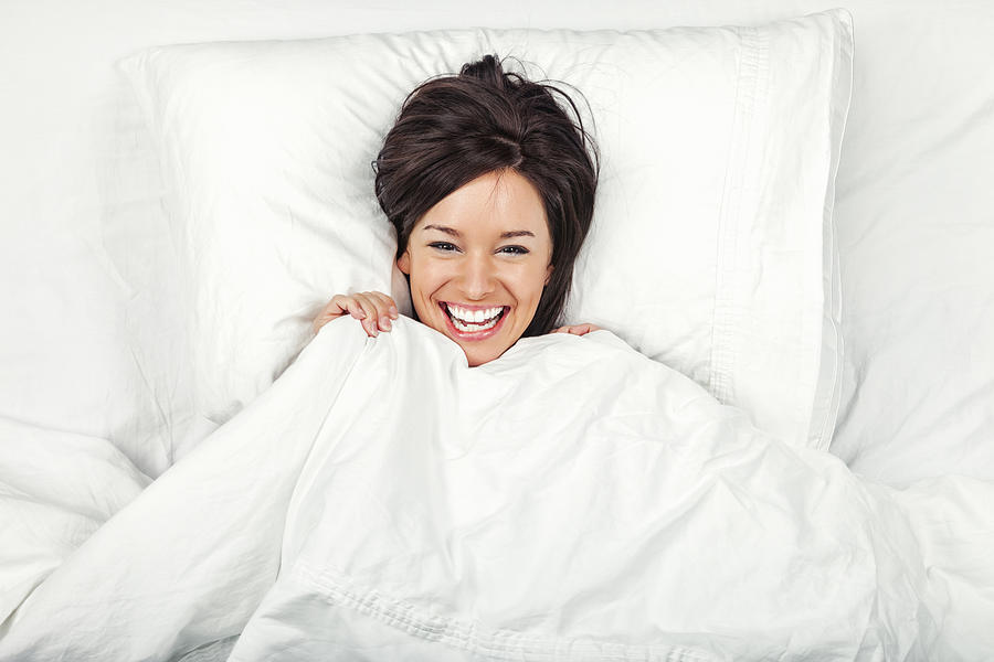 Happy Young Woman in Bed #1 Photograph by Jhorrocks