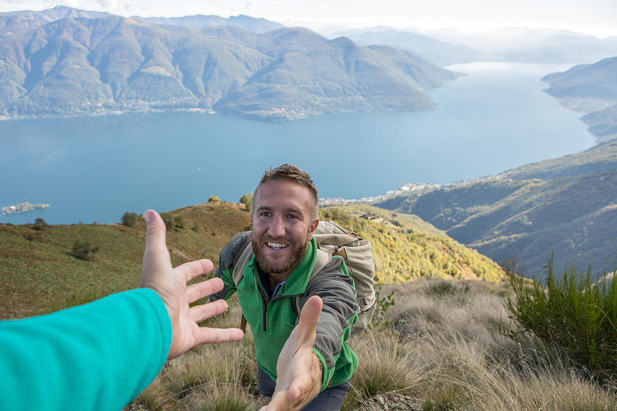 Hiker pulls out hand to get assistance from teammate #1 Photograph by Swissmediavision