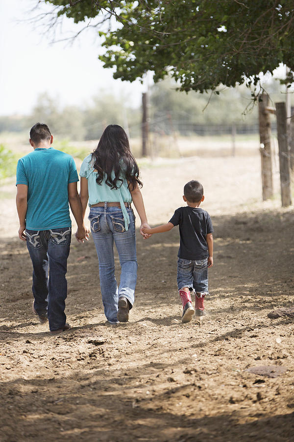 Hispanic mother, father and son walking on ranch #1 Photograph by Hill Street Studios