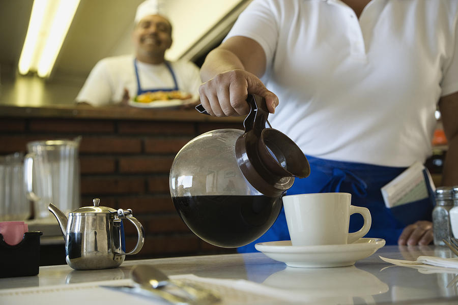 Hispanic waitress pouring coffee #1 Photograph by Hill Street Studios