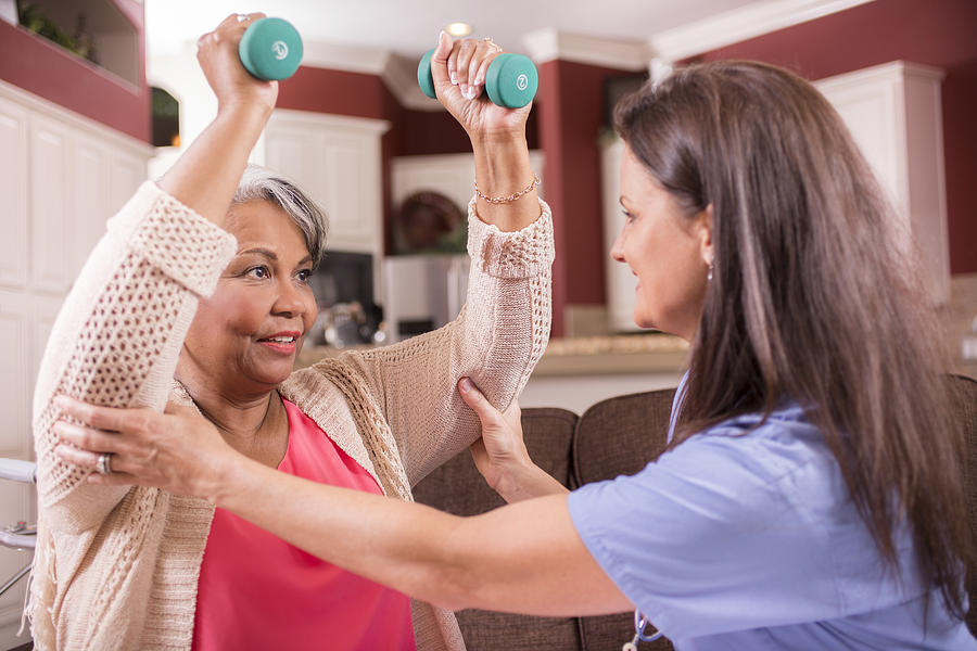 Home healthcare nurse, physical therapy with senior adult woman. #1 Photograph by Fstop123