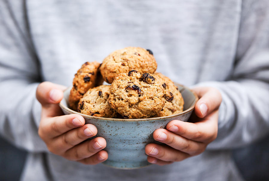 Homemade freshly baked oatmeal cookies in kid`s hands #1 Photograph by Ekaterina Smirnova