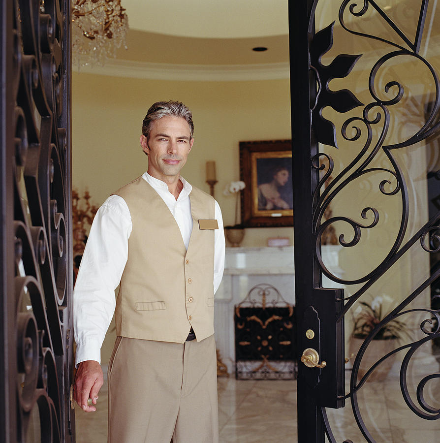 Hotel attendant standing in doorway, portrait #1 Photograph by Siri Stafford